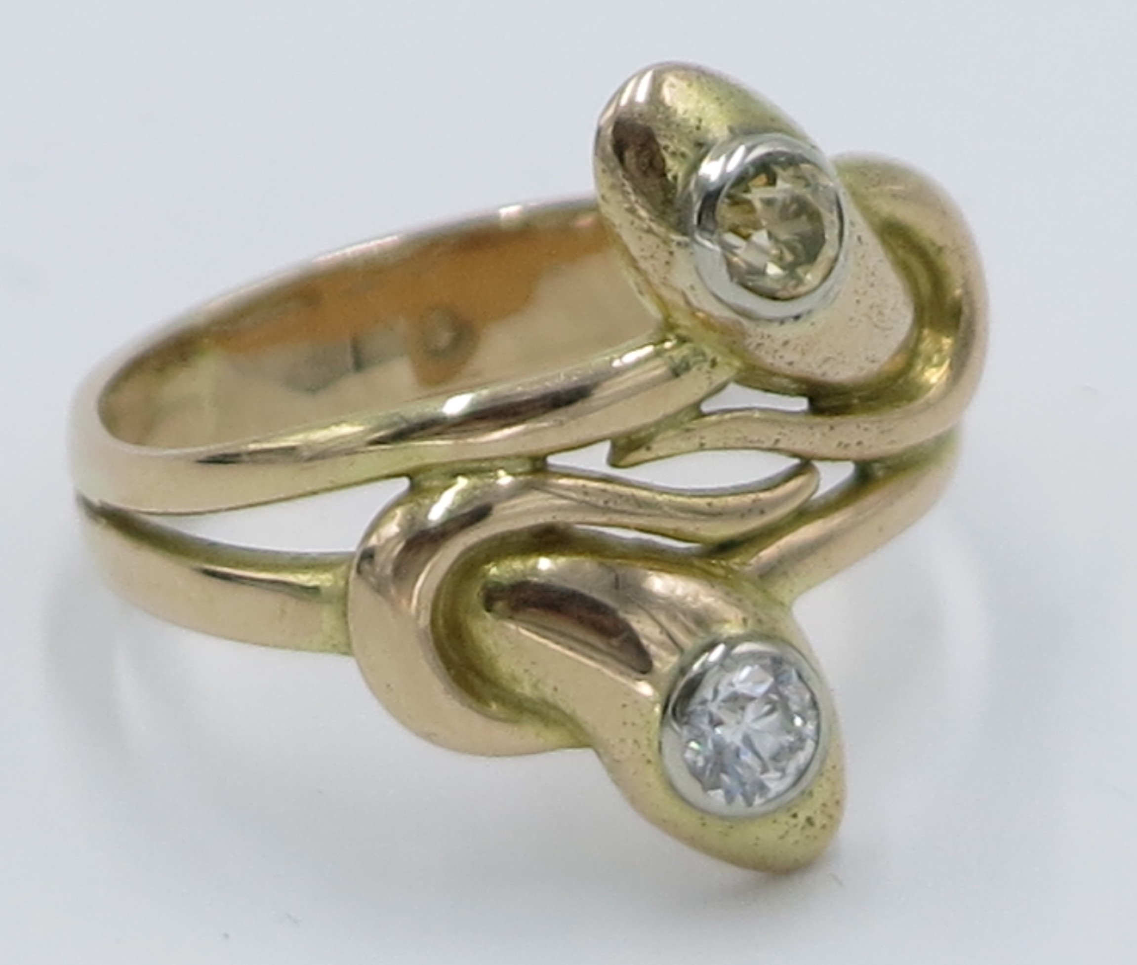A high purity gold snake entwined ring, set with a white diamond and a yellow diamond.