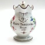 A polychrome painted creamware jug,19th century, painted with flowers and inscribed 'Mary Tregunna,