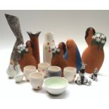 Four contemporary pottery figures of stylised women holding flowers, the largest 31cm,