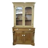 A Victorian pine bookcase, with a pair of arched glazed doors,