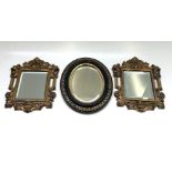 A pair of gilt metal wall mirrors, early 20th century, 33 x 26cm and an ebonised oval wall mirror.