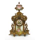 A French gilt metal and porcelain mounted mantel clock, with urn finial,