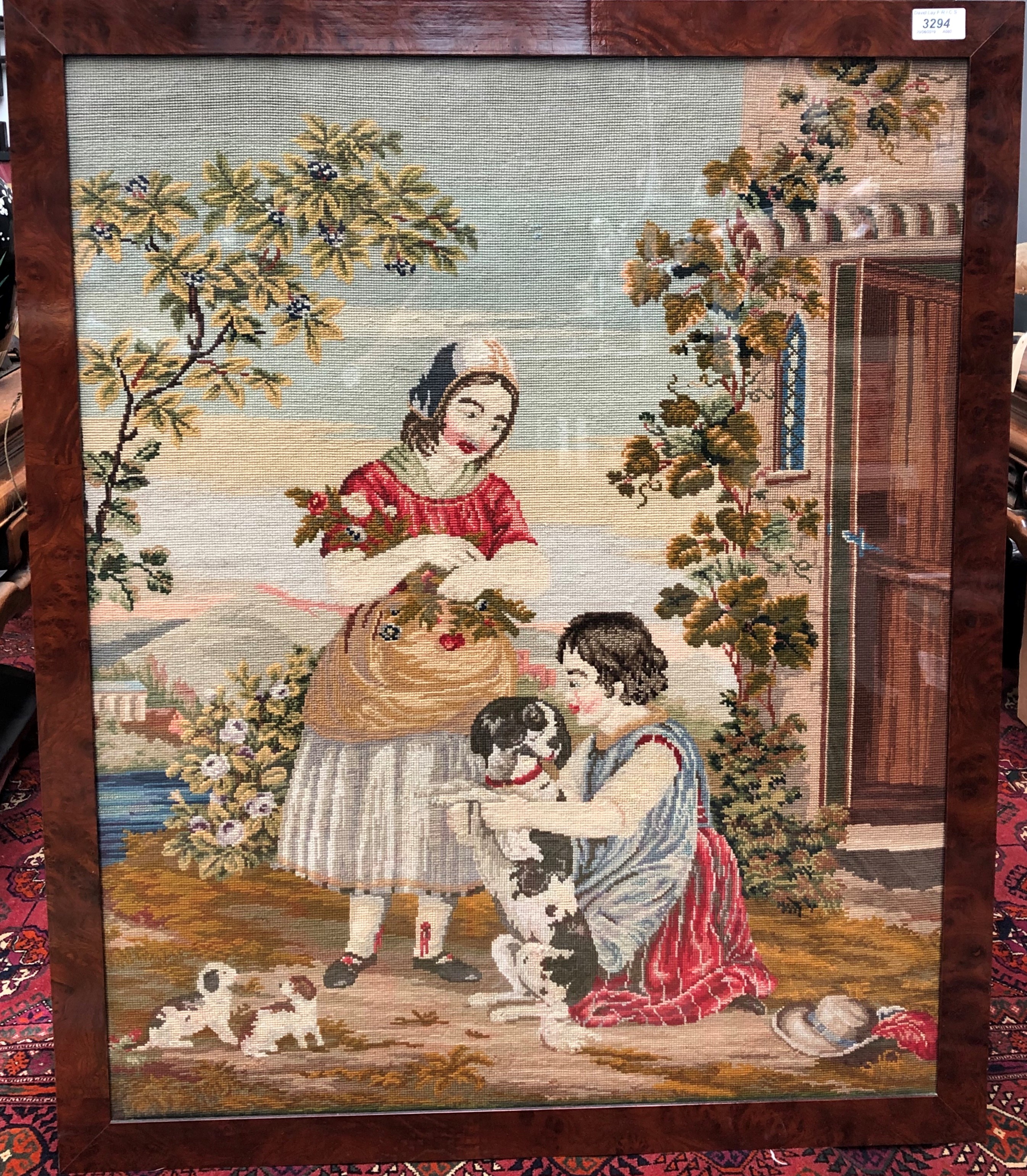 A needlepoint picture, early 20th century of a woman, child and dog, 88 x 72.5cm.