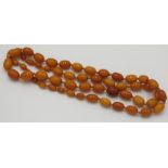 A long string of amber beads, the largest approximately 17 mm, 57.3 g.