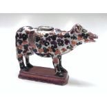 A pink lustre cow creamer and cover, 19th century, height 11cm, length 17cm.