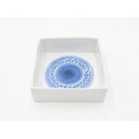 A rare Troika white square ashtray, the inside with a blue rosette,