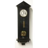 A Vienna regulator wall clock, in ebonised case with architectural arched pediment,