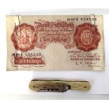 A pocket folding fork and corkscrew, together with a Bank of England 10 shilling note.