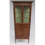 An Edwardian satinwood standing corner cupboard, with a pair of glazed doors,