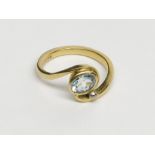 An 18ct gold ring in Art Nouveau style set an aquamarine alongside a white gold bead.