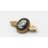 A high Victorian gold brooch with a central hard stone carved cameo surrounded by pearls,