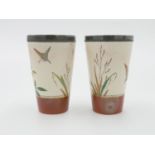 A pair of Pinder Bourne & Co beakers, painted,