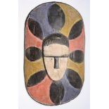 A wooden African Fang tribal polychrome shield mask, Gabon, height 48cm width 29cm.