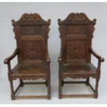 A pair of 17th century style oak wainscott armchairs, height 125cm, width 62.5cm.