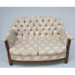 An Arts and Crafts oak sofa, with William Morris style upholstery, height 74cm, width 123cm.