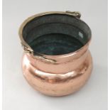 A large copper cauldron or log bin, 19th century, of bellied form,