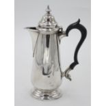 A silver hot water jug with tapering body, moulded foot and vase shaped finial in Georgian style,