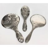 A matching silver mounted brush and vanity mirror repousse decorated with cherubs,