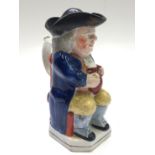 An English pottery Toby jug and cover, 19th century, of traditional design, height 24.5cm.