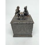 A Continental cast iron square tobacco box and cover, 19th century, cast with figures playing cards,