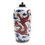 A Chinese porcelain vase and cover, Qianlong mark, with two red dragons amidst cloud scrolls,
