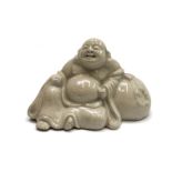A Chinese pottery figure of Hotei, the laughing buddha, signed, height 10.5cm, width 16cm.