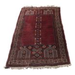 A Turkoman prayer rug, the madder field with rows of candelabra,