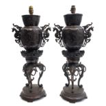 A pair of Japanese bronze urn form lamps, late Meiji Period,