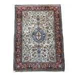 A Ghom rug, Central Persia, the ivory field with a central pale blue lobed pole medallion,