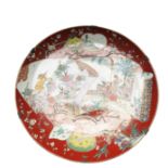 A Japanese Arita porcelain charger, Meiji Period, painted with two scroll panels, one with figures,
