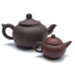 Two Chinese Yixing teapots, the largest with calligraphy to the body and seal to the underside,