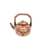 A Japanese red porcelain tea kettle, 19th century, the handle with pierced white metal mounts,