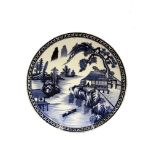A Japanese Arita porcelain charger, circa 1880, painted with a figure in a lakeside pavillion,
