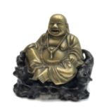 A Chinese brass figure of Hotei, circa 1900, seated on a carved hardwood stand, height 19cm,