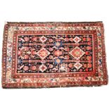 A North West Persian rug, the indigo field with linked lozenge medallions, palmettes,