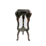 A Chinese hardwood jardiniere stand, 19th century, the circular top on carved elephant mask legs,