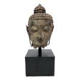 A large Thai or Indian bronze head of Buddha, height 63cm, on a square plinth, total height 100cm.