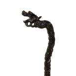 A Chinese huali wood staff, 19th century, the handle carved with a stylised dragon, height 144cm.