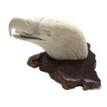 A carved elk horn model of an American eagles head, early 20th century, on a wooden plinth, signed,