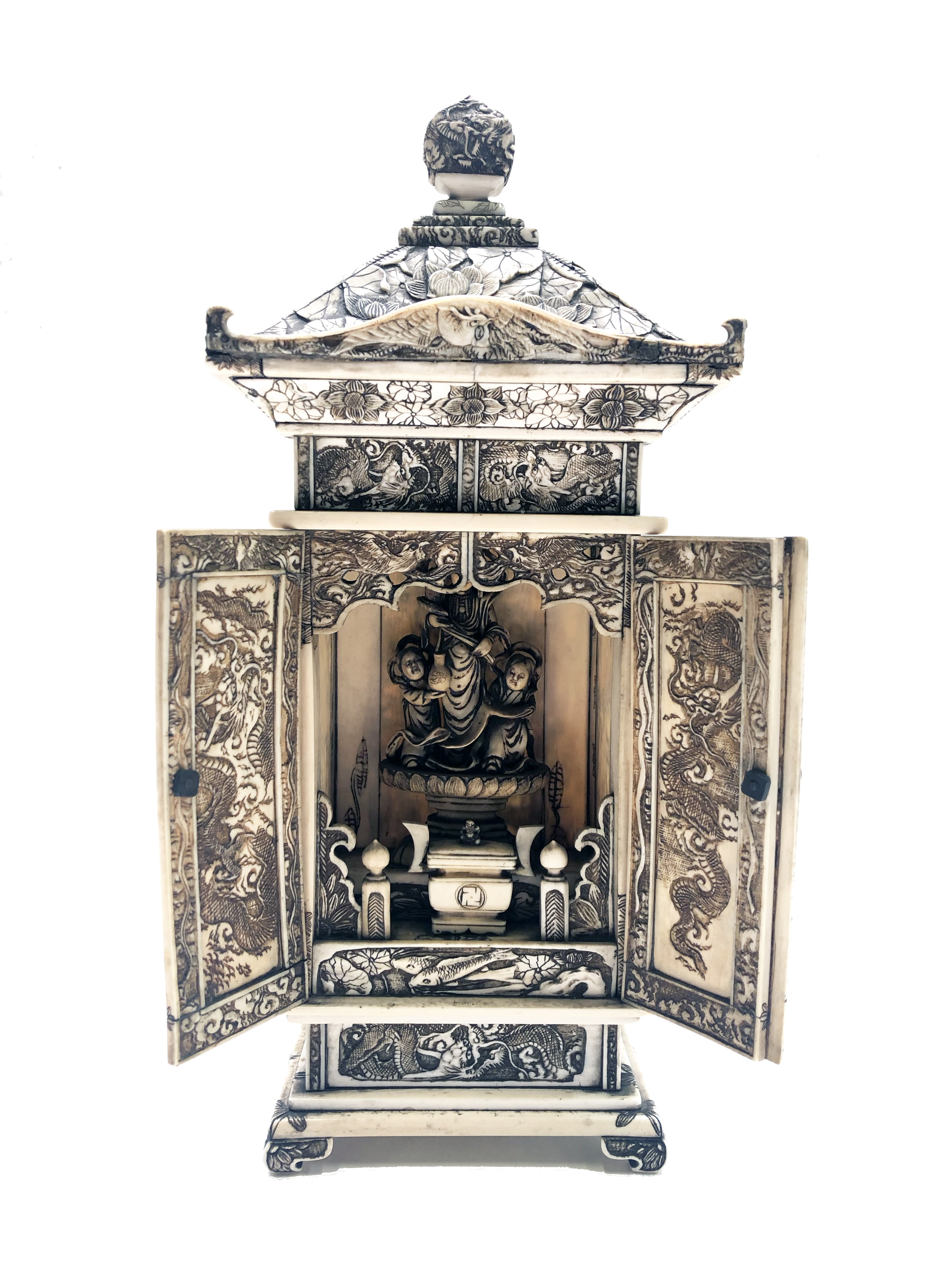 A Japanese carved ivory shrine, late Meiji period, decorated throughout with figures in landscapes,