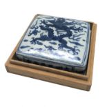 A Chinese blue and white porcelain inkstone, decorated with a stylised dragon amongst cloud scrolls,