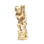 A Japanese ivory okimono of a farmer, circa 1900, with a bundle of flowers over his shoulder,