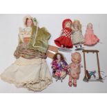 Six miniature porcelain dolls and a cast swing.