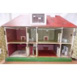 A large plywood dolls house, some outer panels with "brick" effect paper, tin plate windows,