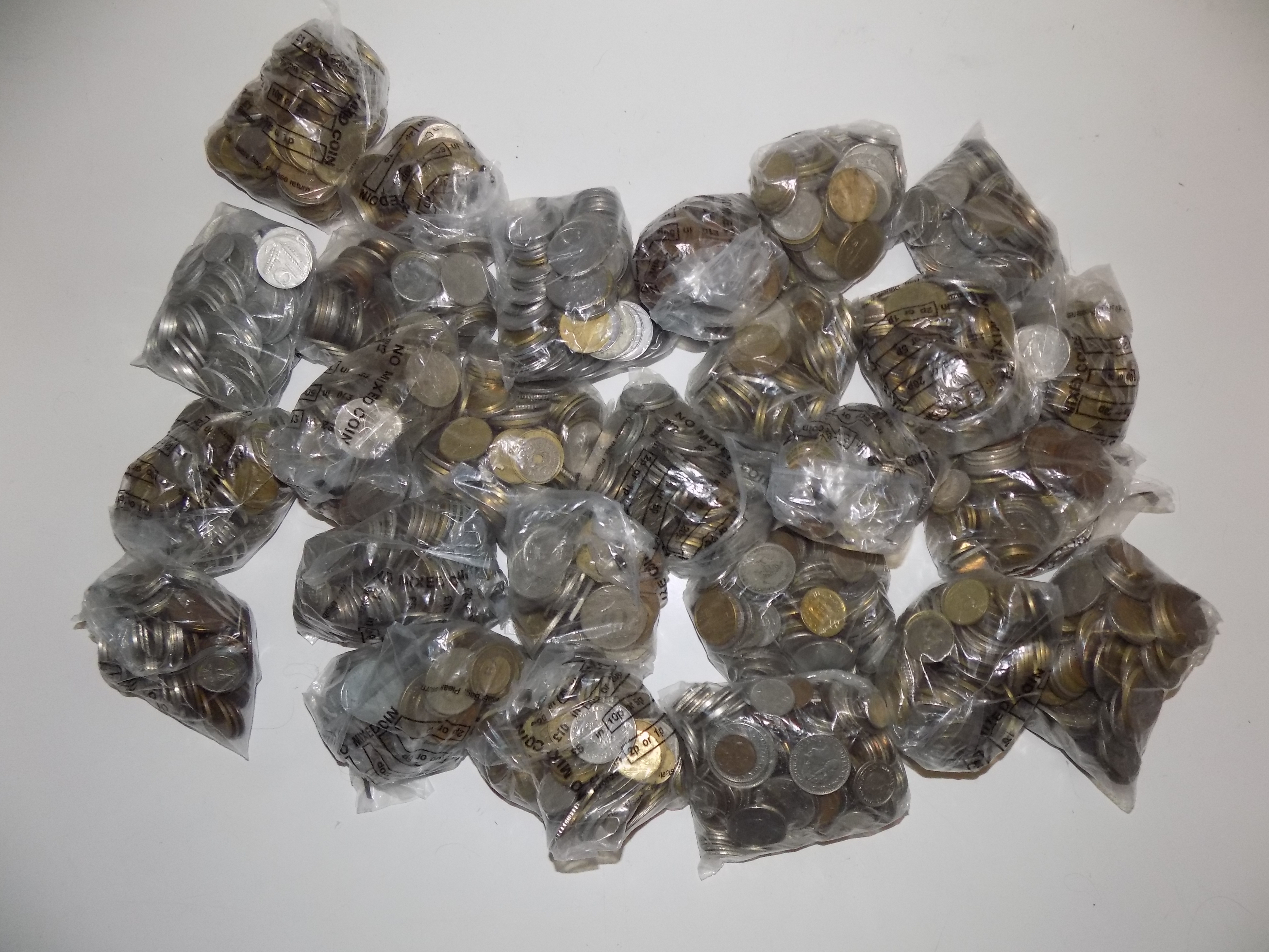 A very heavy accumulation of World coins in plastic bank bags.