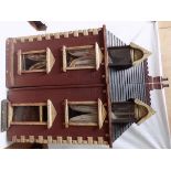 A large wood early 20th century dolls house, the two halves pull apart to reveal the rooms,