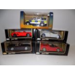 Four 1/18 scale models by Maisto and a 1/18 model of a Land Rover police vehicle, each boxed.