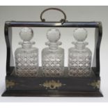 An early 20th century coromandel tantalus with three hobnail cut decanters, height 37cm (overall),