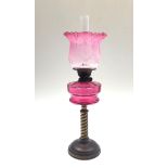 A brass and cranberry glass oil lamp, circa 1900, height 68cm.