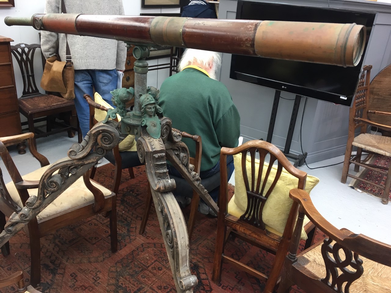 A Victorian brass and wood telescope on an elaborately carved wood tripod stand with metal Roman